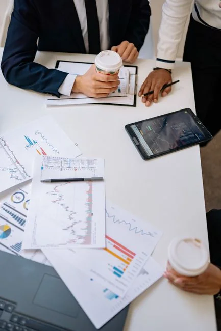 A bird’s-eye view of charts and a smartphone in an office, highlighting data analytics.
